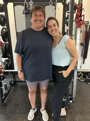 Donna and her trainer Ana at the gym, celebrating progress.