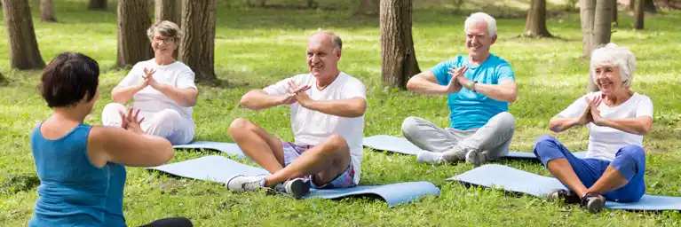 Outdoor group of seniors exercising, focused on wellness and mindfulness