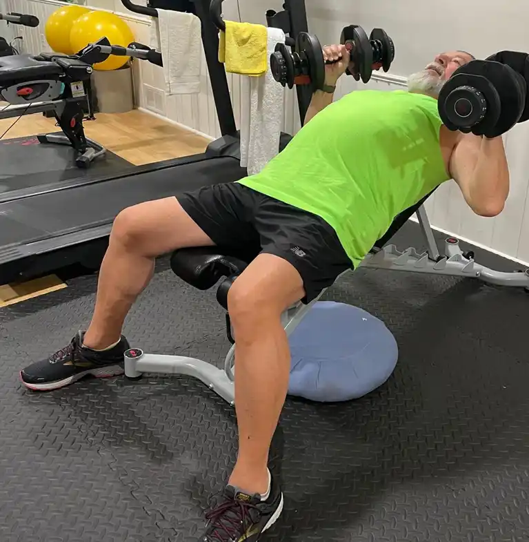 Peter performing dumbbell chest press exercises as part of his strength training training program